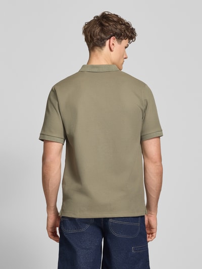 Männermodel trägt Regular Fit Poloshirt mit Strukturmuster Modell 'AUSTIN' von Jack & Jones in Olivgrün, Material-Mix, Rückansicht Ganzkörperansicht.