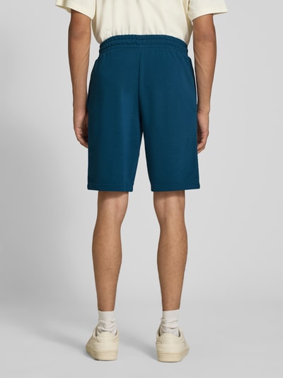 Männermodel trägt Shorts mit Logo und elastischem Bund von PUMA in Blau, Baumwoll-Mix, Regular Fit, Ganzkörperansicht Rückansicht.