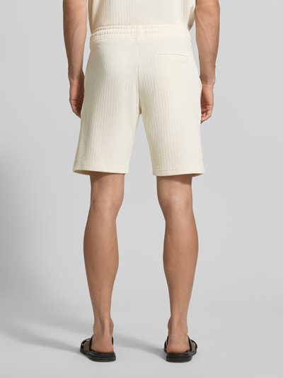 Männermodel draagt Regular Fit Shorts met tunnelkoord van MCNEAL, katoenmix met stretch, steekzakken, achterzak, binnenbeenlengte 23 cm, bandwijdte 43 cm, regular fit, kleur crème, gestructureerde textuur, ganzonsaanzicht achteraan.