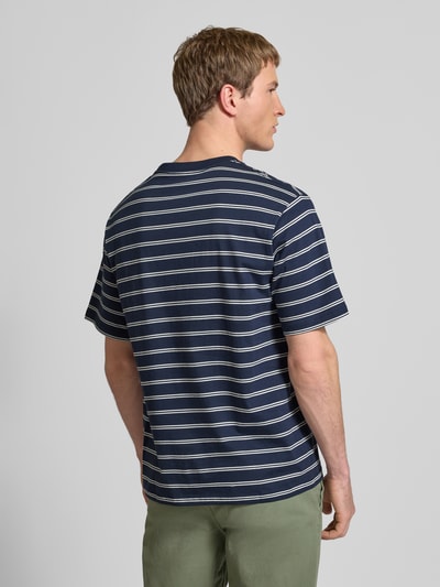 Männermodel trägt T-Shirt mit Streifenmuster und Rundhalsausschnitt von JACK & JONES aus reiner Baumwolle, Regular-Fit, Dunkelblau mit weißen Streifen, Rückenlänge 62 cm, Stitching, Ganzkörperansicht Rückansicht.