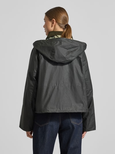 Frauenmodel trägt Regular Fit Funktionsjacke aus reiner Baumwolle Modell 'LIZA' von Barbour, czarna kurtka funkcyjna z kaptur, stójka, metalowe akcenty, długi rękaw, krój regular fit, efekt: jednolity kolor, materiał: bawełna, widok całej sylwetki z tyłu.