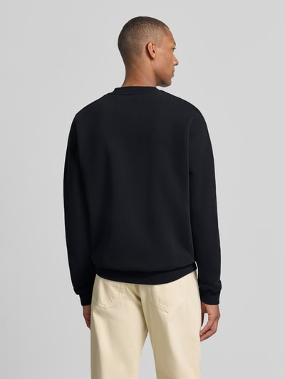Męski model nosi czarną bluzę Regular Fit Sweatshirt aus reiner Baumwolle model 'BAARO' od ARMEDANGELS, jednolity kolor, tekstura gładka, widok całej sylwetki z tyłu.