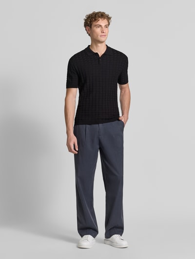 Männermodel trägt Regular Fit Poloshirt aus Viskose-Mix Modell 'Maglia' von Armani Exchange, schwarze Stepp-Optik, Ganzkörperansicht von vorne.
