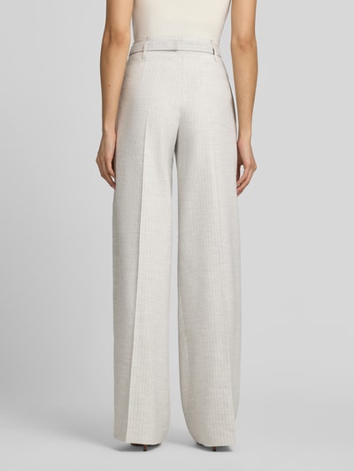 Frauenmodel trägt Weite Hose aus Leinen-Mix mit Gürtelschnalle von HUGO, Optik:Allover-Muster, Nadelstreifen, Passform Wide-Leg, Material Leinen-Mix, Ganzkörperansicht Rückansicht.