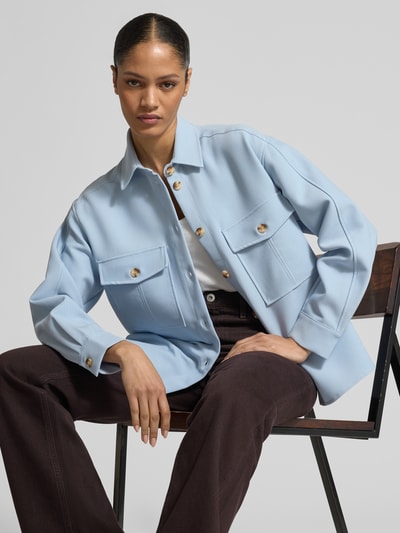 Frauenmodel trägt Relaxed Fit Bluse mit Brusttaschen von Jake*s Collection in Hellblau, Material-Mix mit Viskose-Anteil, Knopfleiste, Hemdblusenkragen, Ganzkörperansicht von vorne.