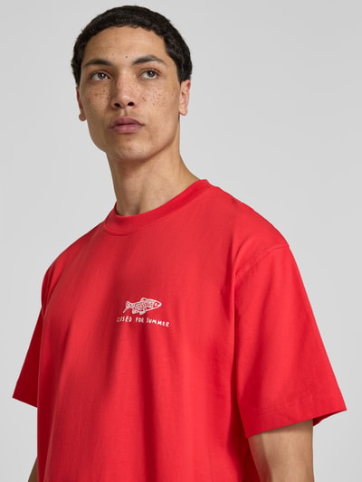 Männermodel trägt Regular Fit T-Shirt mit Statement-Print von Closed in Rot, reine Baumwolle, Rundhalsausschnitt, Nahaufnahme Oberkörper.