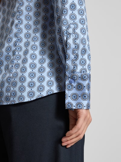Frauenmodel trägt Slim Fit Bluse im Allover-Look mit Stehkragen von Eterna, blau gemustert, Damen, Knopfleiste, Nahaufnahme Oberkörper. Rückenlänge bei Größe 36: 68 cm, Ärmellänge bei Größe 36: 61 cm.