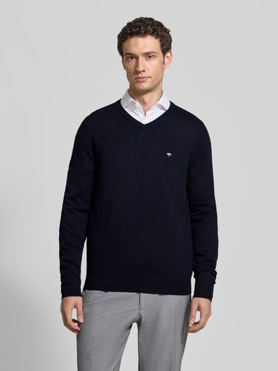 Männermodel trägt Regular Fit Strickpullover aus Baumwoll-Mix mit Kaschmir-Anteil von Fynch-Hatton in Dunkelblau, Ganzkörperansicht von vorne. Rückenlänge bei Größe M: 67 cm, Ärmellänge bei Größe M: 68 cm, V-Ausschnitt, elastische Abschlüsse, feine Strickstruktur.