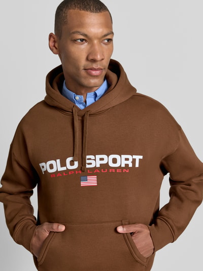 Männermodel trägt Relaxed Fit Hoodie aus katoenmix van Polo Ralph Lauren in bruin met logo, Nahaufnahme Oberkörper.