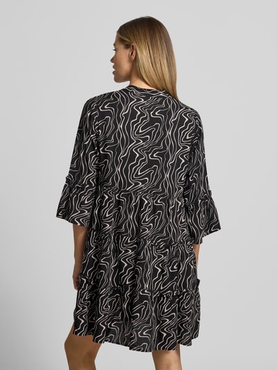 Frauenmodel trägt sukienka koszulowa Ausgestelltes Blusenkleid aus reiner Viskose Modell 'EASY JOY' von Vero Moda, efekt: wzór na całej powierzchni, krój: rozkloszowana, długość: mini, dekolt: henley, marszczenie, rękaw o dł. 3/4, rozszerzane rękawy, prosty dół, materiał: wiskoza, Ganzkörperansicht Rückansicht.