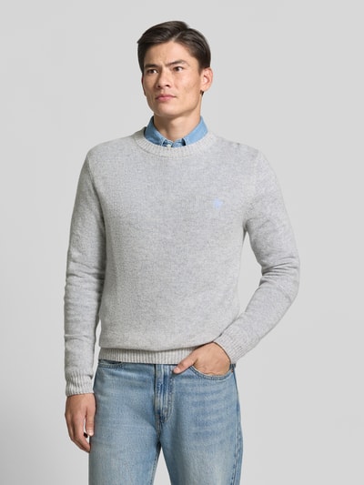 Männermodel trägt Slim Fit Strickpullover aus reiner Wolle mit Label-Stitching von MCNEAL in Hellgrau, gerippte Abschlüsse, Nahaufnahme Oberkörper.