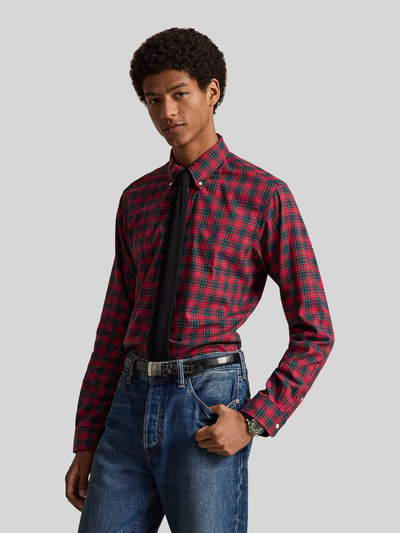 Männermodel trägt Custom Fit Freizeithemd aus reiner Baumwolle von Polo Ralph Lauren in Rot-Schwarz-Karo, Ganzkörperansicht von vorne.