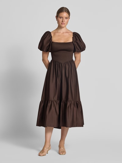 Frauenmodel trägt Cocktailkleid mit Smok-Details und Puffärmeln von Jake*s Cocktail, A-Linie, reine Baumwolle, Ganzkörperansicht von vorne.