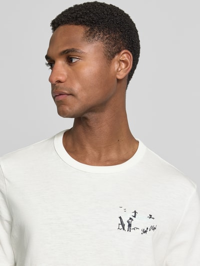 Męski model nosi Regular Fit T-Shirt aus reiner Baumwolle od s.Oliver RED LABEL, efekt: jednolity kolor, krój regular fit, nadruk z motywem, rękaw: krótki rękaw, materiał: bawełna, zbliżenie na górną część torsu