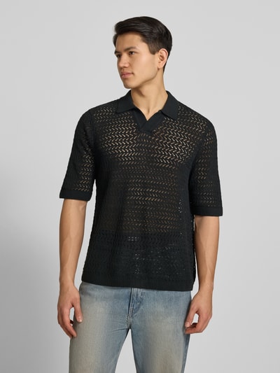 Männermodel trägt Regular Fit Poloshirt aus Baumwoll-Mix Modell 'NYLE' von Only & Sons in schwarzer Strickoptik, Strukturmuster, Nahaufnahme Oberkörper.