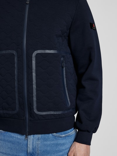 Männermodel trägt Jacke mit Zweiwege-Reißverschluss Modell 'KYARR' von Peuterey, dunkelblauer Material-Mix, Nahaufnahme Oberkörper. Regular Fit, Baumwoll-Anteil, Stehkragen, Reißverschlusstaschen, dezente Struktur und glatte Textur.