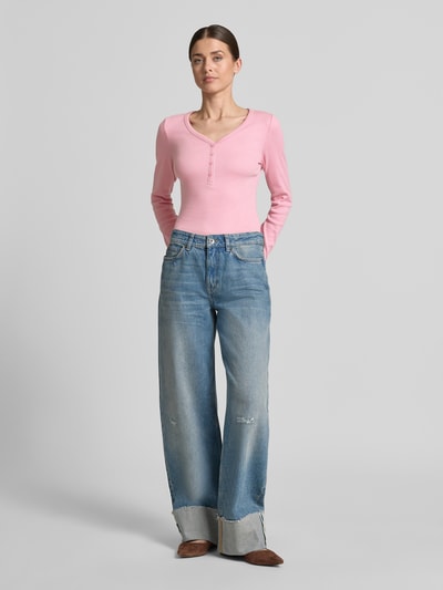 Kobiece model nosi Regular Fit Langarmshirt mit Henley-Ausschnitt von Tom Tailor Denim, efekt: jednolity kolor, krój: krój regular fit, dekolt: dekolt henley, rękawy: długi rękaw, materiał: mieszanka bawełny, Ganzkörperansicht von vorne.
