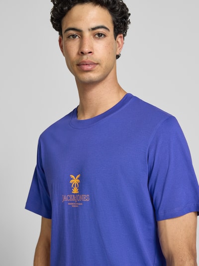 Männermodel trägt Regular Fit T-Shirt mit Logo-Print Modell 'Eres' von Jack & Jones aus reiner Baumwolle in Blau, Nahaufnahme Oberkörper.