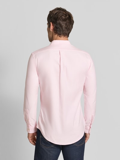 Männermodel trägt slim fit vrijetijdsoverhemd van puur katoen van Polo Ralph Lauren in lichtroze, Ganzkörperansicht Rückansicht.