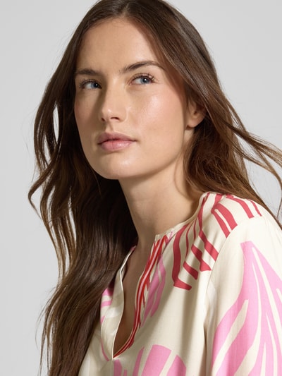 Frauenmodel trägt Regular Fit Langarmbluse aus reiner Viskose von s.Oliver BLACK LABEL mit Allover-Muster in Creme und Rosa, Nahaufnahme Oberkörper.