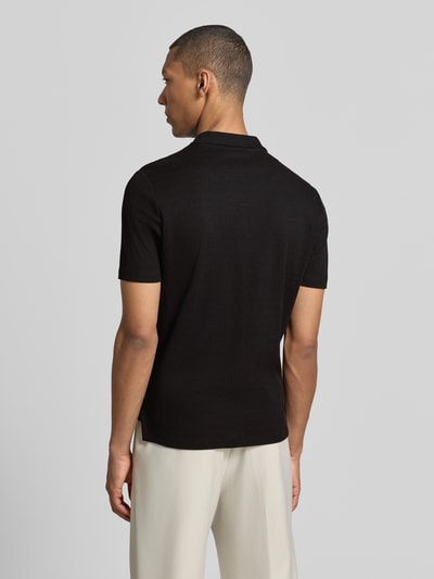 Männermodel trägt schwarzes Modern Fit Poloshirt mit Polokragen und Label-Detail von MARKUP aus reiner Baumwolle, Ganzkörperansicht Rückansicht. Rückenlänge bei Größe M: 70 cm.