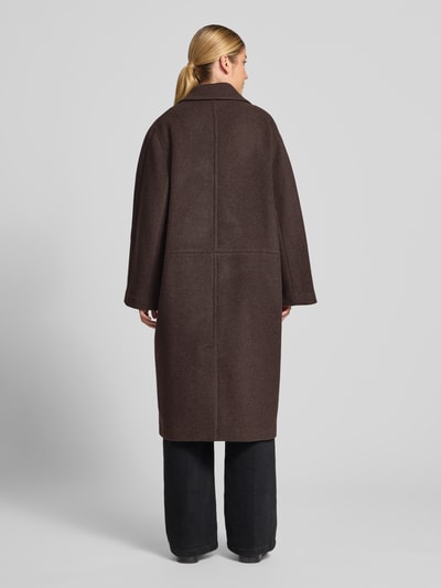 Vrouwenmodel draagt Relaxed Fit lange jas van pure wol van ARMEDANGELS, effen donkerbruin, rechte lijnen, Ganzkörperansicht Rückansicht.