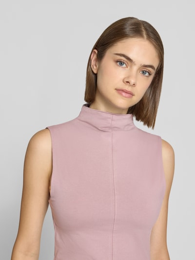 Frauenmodel trägt Slim Fit Top aus Baumwoll-Mix Modell 'Belisa' von Topshop in zartrosé, Stehkragen, feine Textur, Nahaufnahme Oberkörper.