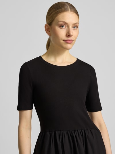 Vrouwenmodel draagt Midikleid in plooien-look van Christian Berg Woman Selection in zwart, katoenmix, getailleerd, ronde hals, met korte mouwen, nahaufnahme bovenlichaam.