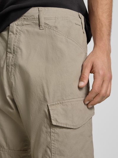 Männermodel trägt Straight Fit Cargohose mit Gesäßtaschen von G-Star Raw aus Reine Baumwolle, Eingrifftaschen, Knopf-Reißverschluss, Nahaufnahme Oberkörper.