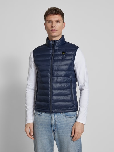 Männermodel trägt Steppweste mit Zweiwege-Reißverschluss Modell 'Arvale' von Blauer Usa in Dunkelblau, glatte Textur, Ganzkörperansicht von vorne, Regular Fit, Stehkragen, Reißverschlusstaschen, Rückenlänge 65 cm, Schulterbreite 44 cm, Brustweite 52 cm.