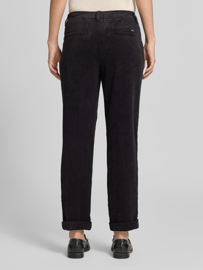 Frauenmodel trägt Cordhose mit elastischem Bund von Christian Berg Woman in dunklem Material-Mix mit Stretch-Anteil, strukturierte Oberfläche, Tapered Fit, angedeutete Gesäßleistentaschen, seitliche Eingrifftaschen, Bundweite bei Größe 36: 38 cm, Innenbeinlänge 70 cm, Ganzkörperansicht Rückansicht.