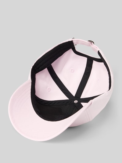 Produktfoto, Basecap aus reiner Bio-Baumwolle Modell 'YENAAS' von Armedangels, Optik: Unifarben, Logo-Stitching, verstellbarer Riegel, glatte strukturierte Oberfläche, Innenansicht mit schwarzen Nähten auf rosafarbenem Stoff