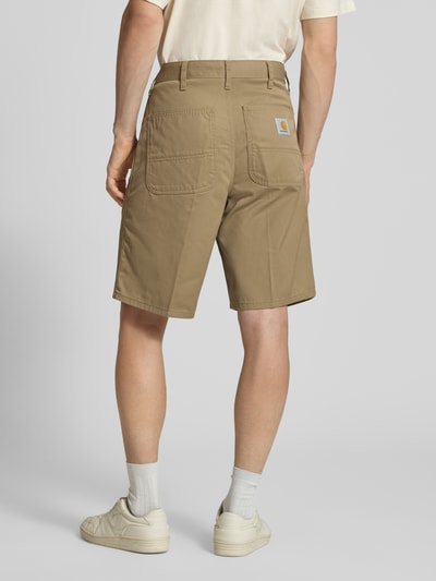 Männermodel trägt Bermudas mit Gesäßtaschen von Carhartt Work In Progress in Beige, Material-Mix mit Baumwoll-Anteil, Regular-Fit, Eingrifftaschen, Bundweite 45 cm, Innenbeinlänge 26 cm, Ganzkörperansicht Rückansicht.