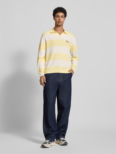Männermodel trägt Regular Fit Strick-Poloshirt mit Block-Streifen von REVIEW, reine Baumwolle, Logo-Bestickung, Ganzkörperansicht von vorne.