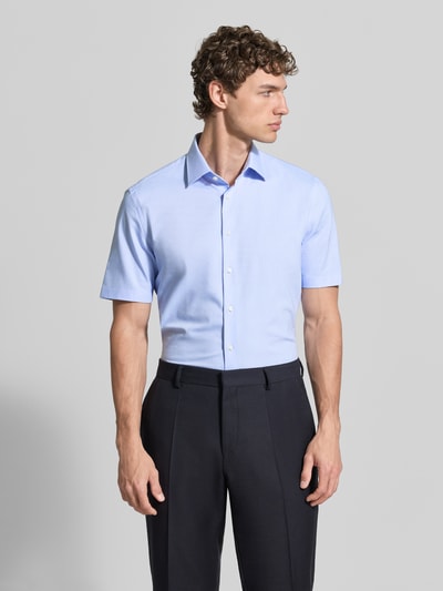 Männermodel trägt Slim Fit Business-Hemd mit Kentkragen von Jake*s, hellblau, kurze Ärmel, Knopfleiste, Baumwoll-Mix, Ganzkörperansicht von vorne.