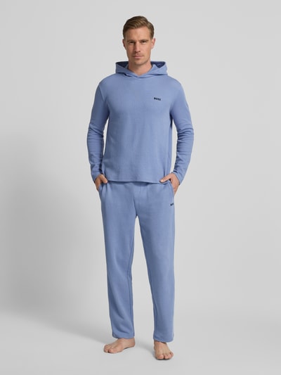 Männermodel trägt Comfort Fit Langarmshirt aus Baumwoll-Mix Modell 'WAFFLE' von BOSS in Unifarben mit Kapuze, Label-Schriftzug, Ganzkörperansicht von vorne.
