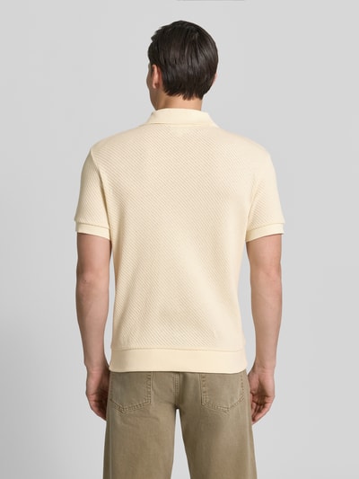 Männermodel trägt Regular Fit Poloshirt aus reiner Baumwolle von Lacoste, Optik: Unifarben, Struktur, Ganzkörperansicht Rückansicht.