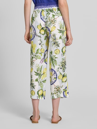 Kobiece model nosi Straight Fit Stoffhose aus reiner Viskose mit Allover-Motiv-Print von Marc Cain, białe spodnie materiałowe z nadrukiem z motywem na całej powierzchni, częściowo elastyczny pas, szerokość w rozmiarze 36: 40 cm, długość wewnętrzna nogawki w rozmiarze 36: 64 cm, skrócony krój, widok całej sylwetki od tyłu.