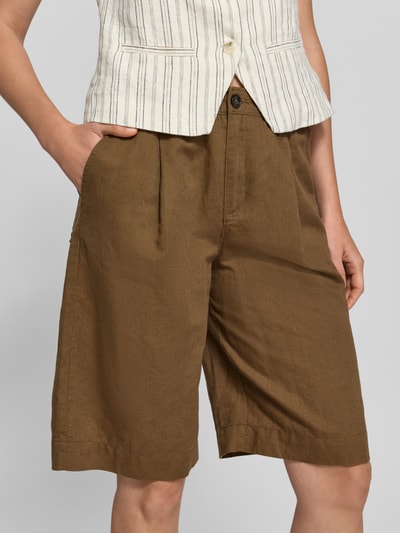 Frauenmodel trägt Regular Fit Bermudas aus Leinen-Baumwoll-Mix von s.Oliver RED LABEL, efekt: jednolity kolor, naszywka z logo, szlufki na pasek, zapięcie na guzik i zamek błyskawiczny, wpuszczane kieszenie, kieszenie z tyłu, wykończenie materiału: tkana faktura, mieszanka lnu i bawełny, Nahaufnahme dolnej części ciała.