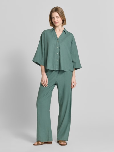 Frauenmodel trägt Boxy Fit Bluse mit V-Ausschnitt Modell 'Lava' von FREE/QUENT in Grün, Leinen-Viskose-Mix, Ganzkörperansicht von vorne.