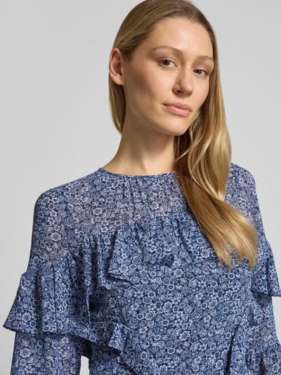 Frauenmodel trägt Minikleid mit Volants von MICHAEL Michael Kors, blauer Allover-Look, Rundhalsausschnitt, Nahaufnahme Oberkörper. Rückenlänge bei Größe S: 86 cm, Brustweite bei Größe S: 44 cm, Ärmellänge bei Größe S: 32 cm.