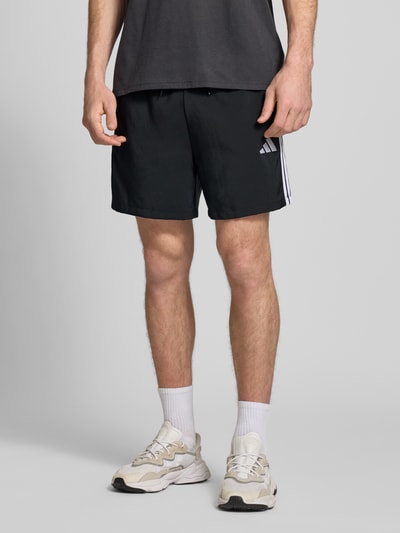 Männermodel trägt Regular Fit Sport-Shorts Modell '3S CHELSEA' von adidas Sportswear, Optik: Unifarben, Logo-Stitching, Kontraststreifen, elastischer Bundabschluss mit Tunnelzug, seitliche Eingrifftaschen, Ganzkörperansicht von vorne.