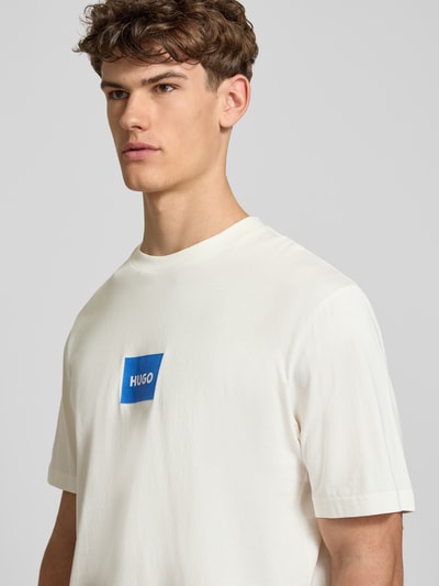Männermodel trägt Regular Fit T-Shirt aus reiner Baumwolle Modell 'NAYONIX' von HUGO, Optik: Unifarben, Label-Print, Rundhals, Kurzarm, Materialverarbeitung: Jersey, Nahaufnahme Oberkörper.