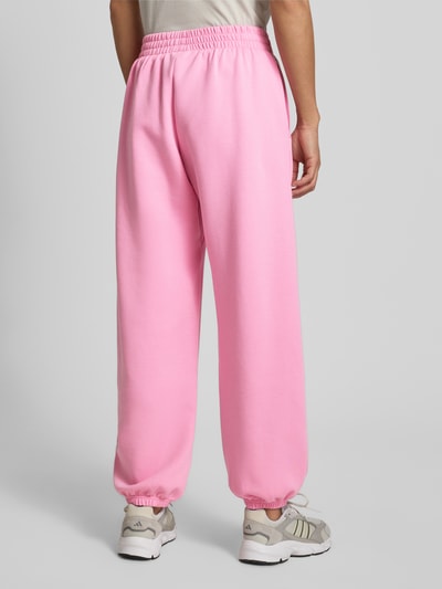 Frauenmodel trägt Loose Fit Sweatpants mit Baumwoll-Anteil von adidas Sportswear in Optik: Unifarben, Materialverarbeitung: Sweat, Ganzkörperansicht Rückansicht.