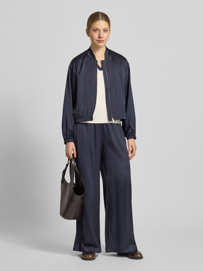 Frauenmodel trägt Strickshirt aus Viskose-Mix mit Polokragen und V-Ausschnitt von Comma, Slim-Fit, dunkel und glatt, Ganzkörperansicht von vorne. Rückenlänge bei Größe 36: 55 cm.