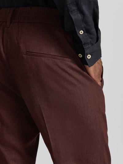 Männermodel trägt Hose aus Leinen-Mix mit Gesäßtaschen von Drykorn, Slim-Fit, Elastischer Bund, Nahaufnahme Gesäßtasche, Leinen-Viskose-Anteil.