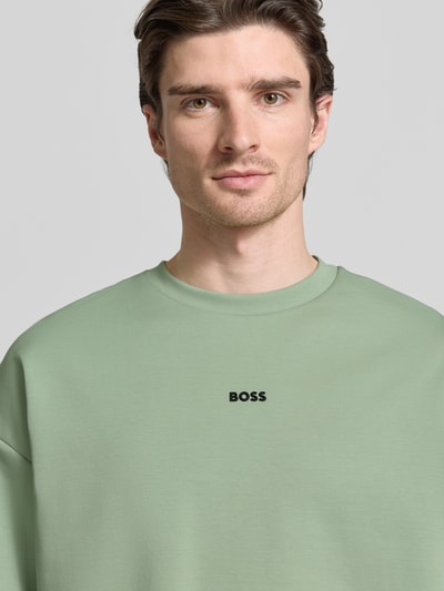 Männermodel trägt Regular Fit Sweatshirt aus Baumwoll-Mix Modell 'STENSON' von BOSS Green in Mintgrün, Label-Schriftzug, Nahaufnahme Oberkörper.