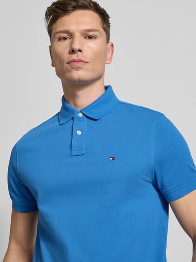 Männermodel trägt Regular Fit Poloshirt aus Baumwoll-Mix von Tommy Hilfiger, Optik: Unifarben, Piqué-Textur, Logo-Stitching, Nahaufnahme Oberkörper.