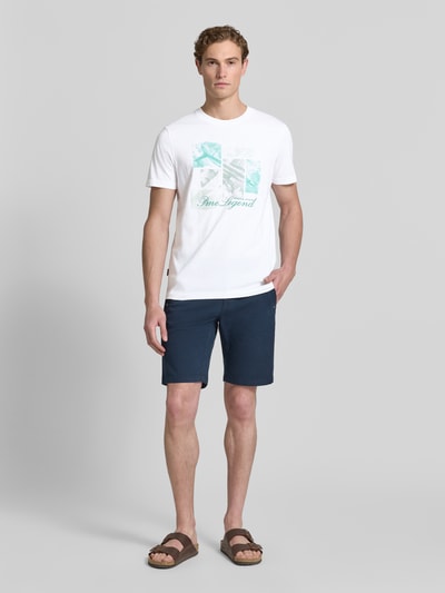Mannelijk model draagt T-shirt met Label-Print en ronde hals van PME Legend, puur katoen, regular fit, ruglengte maat M 72 cm, full body vooraanzicht.