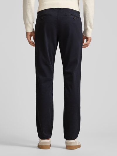 Männermodel trägt Chino mit französischen Eingrifftaschen von Christian Berg Men, Unifarbenes-Design in Dunkelblau, Baumwoll-Elasthan-Mix, Ganzkörperansicht Rückansicht.